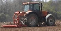 Tracteur avec herse rotative.